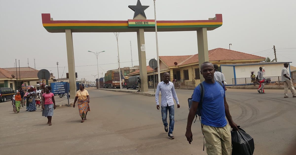 Border gate between Ghana and Togo at Aflao, with trucks waiting in the background