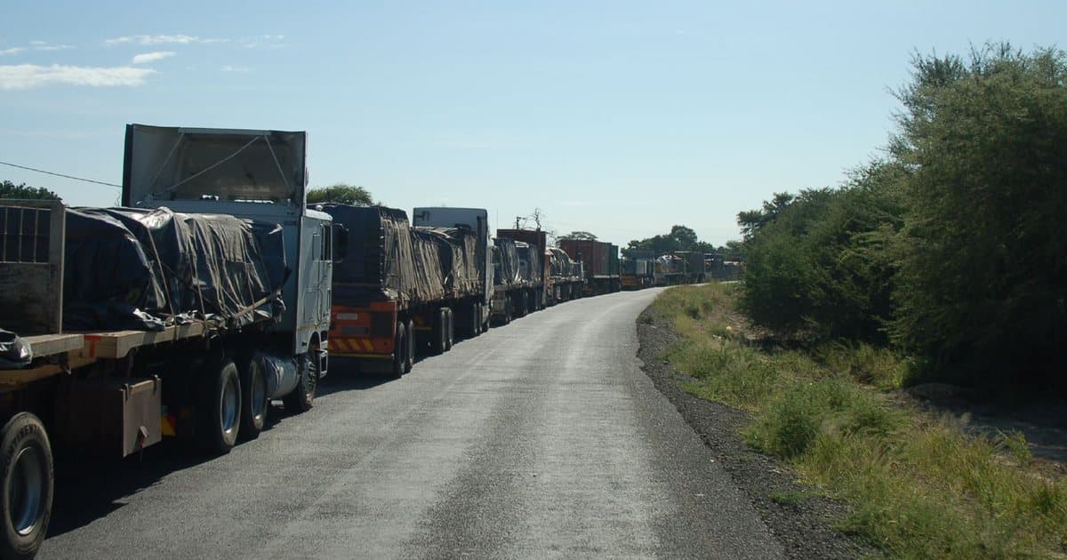 Longue file de camions en attente au bord de la route, plusieurs jours d'arrêt